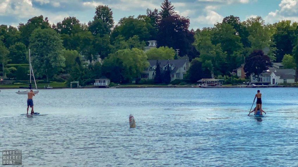 standup paddleboarders enjoy the relaxed lifestyle of Skaneateles Lake New York. 